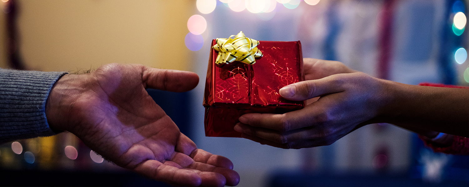 man handing a present off to a woman